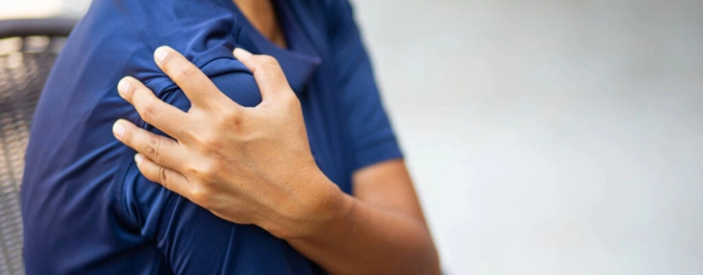 A hand on the shoulder suggests strain reduced through Atlantic Rehab Center’s manual therapy.